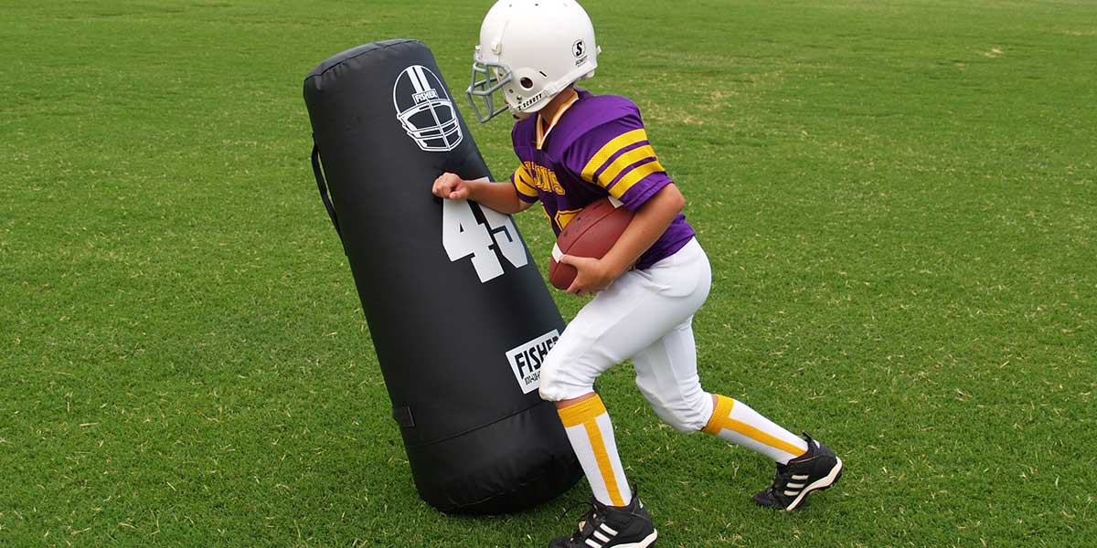 Youth Football Player pushing Football dummy out of the way