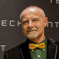 Portrait of Marc Ebtinger with a green shirt and yellow bow tie.