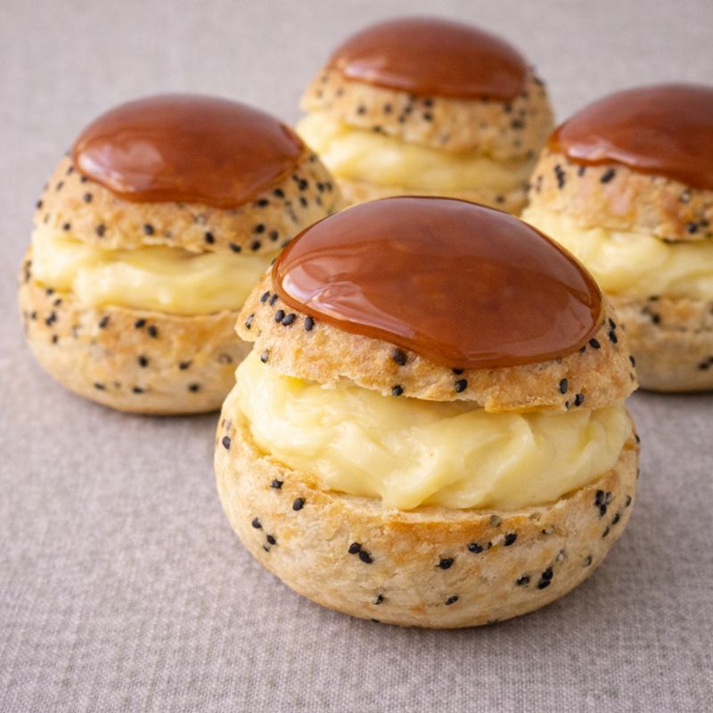Fastelavnsboller af vandbakkelse med sort sesam, vaniljecreme og honningkaramel