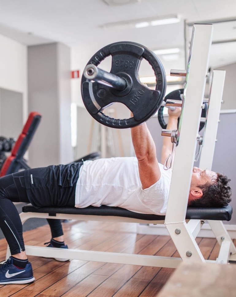 Man tränar bänkpress i gymmet