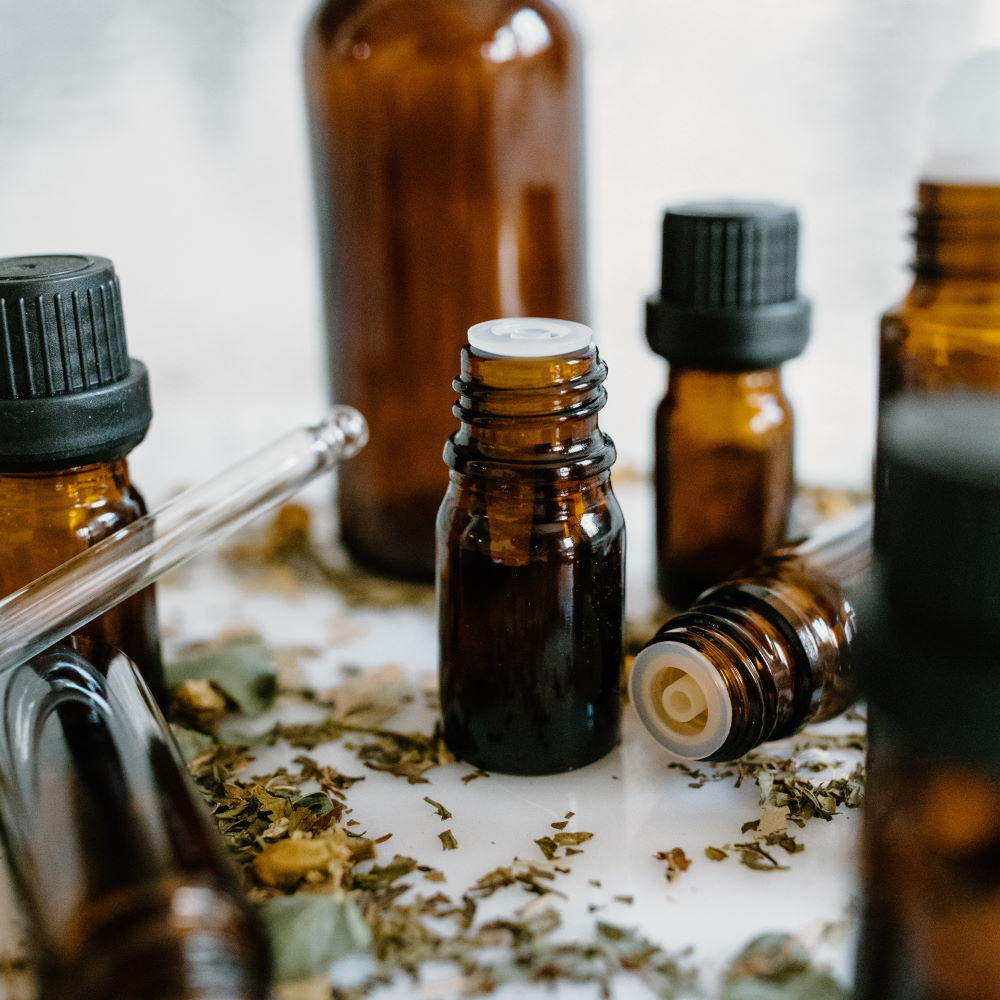 Homeopatiska droppflaskor och torkade örter på ett bord