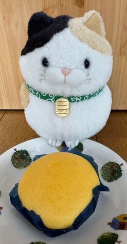今日のおやつはこれニャ！
月見まん！
中身はあんことカスタードで立派なスイーツにゃん！
形も僕にそっくりでまんまるなのニャ！