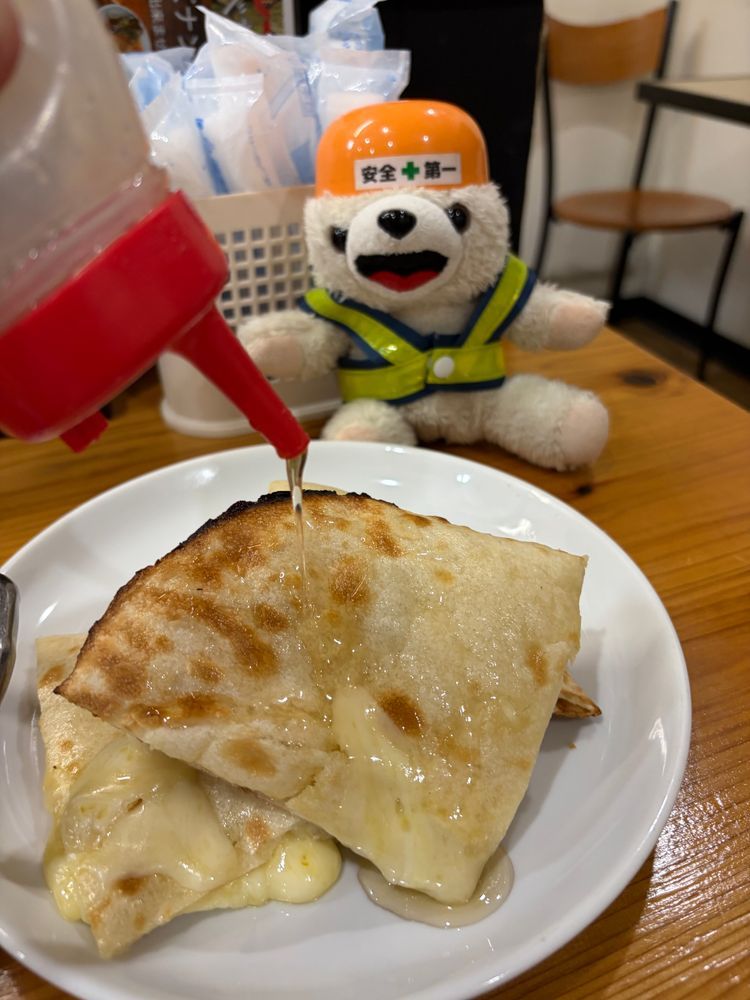 よく見るとチーズナンにハチミツをかけているこぐま