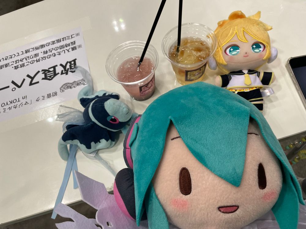 みずうみの そなーれ

みくちゃんたちから こんさーとの しょうたいじょうを うけとった ぼくらは、 ついに まじかるみらい2026の きかくてん かいじょうに やってきた！

みずうみの そなーれを いめーじした おようふくの みくちゃんが おでむかえ！🌻
ごしょうたい ありがとう！
また あえて うれしいな！

そして… ちゅろす！ どりんく！ あいす！ けーきの よよいの よい……😌

ちゅろすは、 るかさんを いめーじした ぴんくいろの ふらんぼわーずあじ！
さくさくで おいしい！
しかも なかの もちもちした ぶぶんが ちょっと ひんやりしてるんだ 
あげものを たべてるのに、 ひんやりしてて… 
すずしげな なつの こんさーとを ついきゅうした ことしの うんえいさんの こだわりを かんじたよ🤩

そして ぼくが いただいたのは、 ぴんくいろの どりんく！
これも るかさんを いめーじした ぴーちちょこぷりんどりんく…！
ぴーちちょこぷりんどりんく……？🤔
ふしぎだよね でも とっても おいしい！
ぴーちふうみの じゅーすに のって、 つめたい ちょこぷりんが つるつる のどを とおる… からだの なかから くーるだうん できちゃうよ🍫

さいごは、 ぴんくと しろの すてぃっくけーき… すいーとすとろべりーすてぃっく🍓 かわいい しーるつきだよ！
しっとり やわらかくて、あまい いちごと みるくの りっちな すてぃっくけーき！
コトコトスープさんと しぇあしながら いただいたんだけど、 ただでさえ おいしさ ばくれつ なのに、 そふとくりーむと あわせたら… おいしくないわけが ない！！

おいしい おかしに つられて ばつまるくんと なかよしの れんくんも あそびに やってきたよ🍌
みんなで おいしいじかん たのしかった〜！
