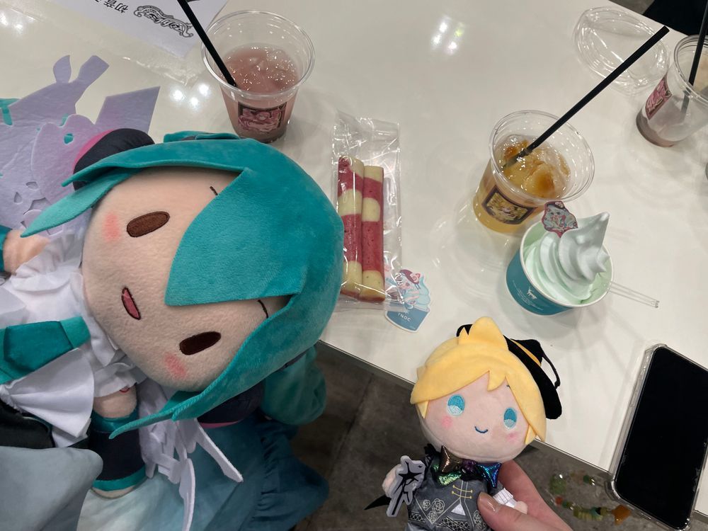 みずうみの そなーれ

みくちゃんたちから こんさーとの しょうたいじょうを うけとった ぼくらは、 ついに まじかるみらい2026の きかくてん かいじょうに やってきた！

みずうみの そなーれを いめーじした おようふくの みくちゃんが おでむかえ！🌻
ごしょうたい ありがとう！
また あえて うれしいな！

そして… ちゅろす！ どりんく！ あいす！ けーきの よよいの よい……😌

ちゅろすは、 るかさんを いめーじした ぴんくいろの ふらんぼわーずあじ！
さくさくで おいしい！
しかも なかの もちもちした ぶぶんが ちょっと ひんやりしてるんだ 
あげものを たべてるのに、 ひんやりしてて… 
すずしげな なつの こんさーとを ついきゅうした ことしの うんえいさんの こだわりを かんじたよ🤩

そして ぼくが いただいたのは、 ぴんくいろの どりんく！
これも るかさんを いめーじした ぴーちちょこぷりんどりんく…！
ぴーちちょこぷりんどりんく……？🤔
ふしぎだよね でも とっても おいしい！
ぴーちふうみの じゅーすに のって、 つめたい ちょこぷりんが つるつる のどを とおる… からだの なかから くーるだうん できちゃうよ🍫

さいごは、 ぴんくと しろの すてぃっくけーき… すいーとすとろべりーすてぃっく🍓 かわいい しーるつきだよ！
しっとり やわらかくて、あまい いちごと みるくの りっちな すてぃっくけーき！
コトコトスープさんと しぇあしながら いただいたんだけど、 ただでさえ おいしさ ばくれつ なのに、 そふとくりーむと あわせたら… おいしくないわけが ない！！

おいしい おかしに つられて ばつまるくんと なかよしの れんくんも あそびに やってきたよ🍌
みんなで おいしいじかん たのしかった〜！
