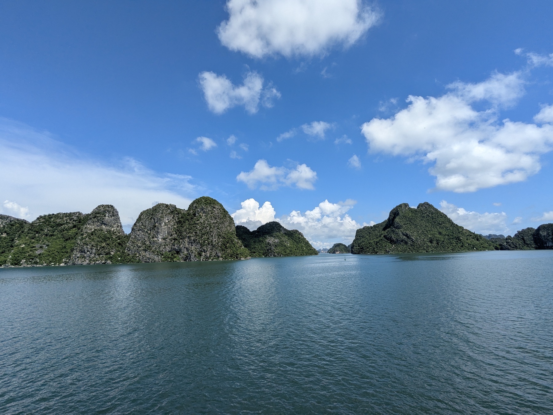 Limestone towers rising from the calm water of Ha Long Bay