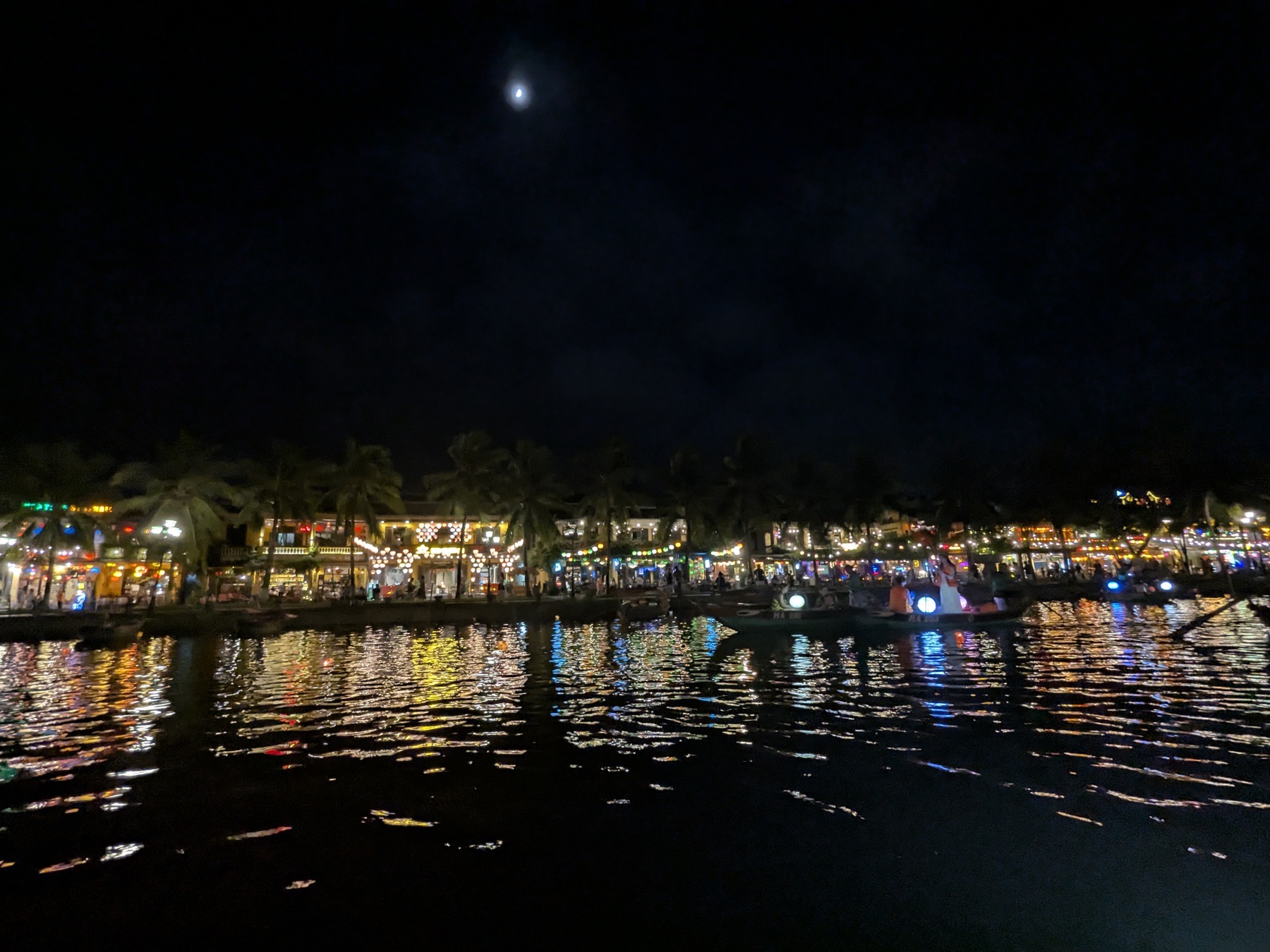 Lantern-lit boats and reflections on the river at night