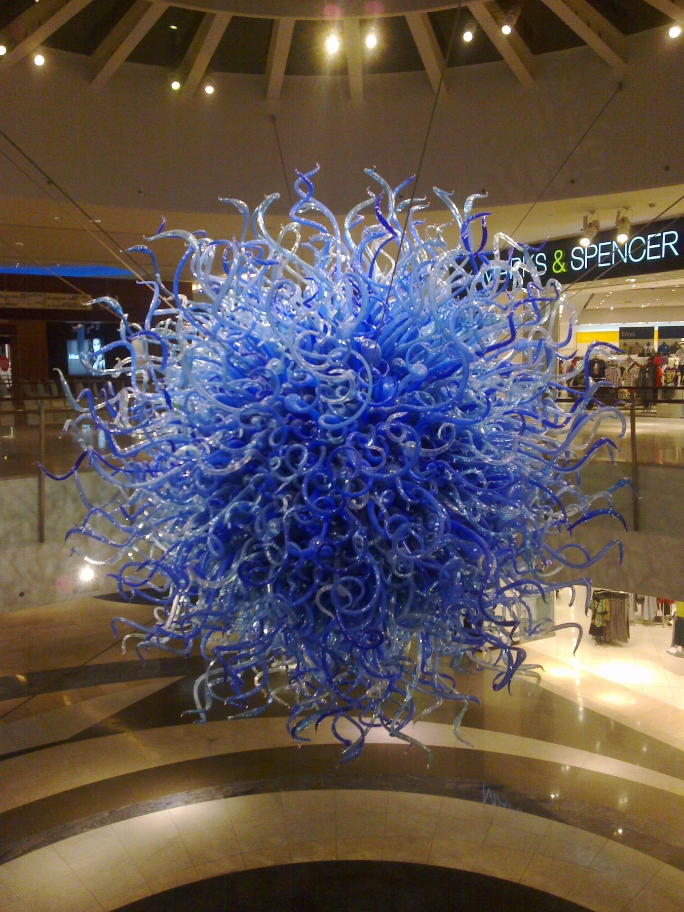 A suspended glass artwork in a modern Kuwait interior