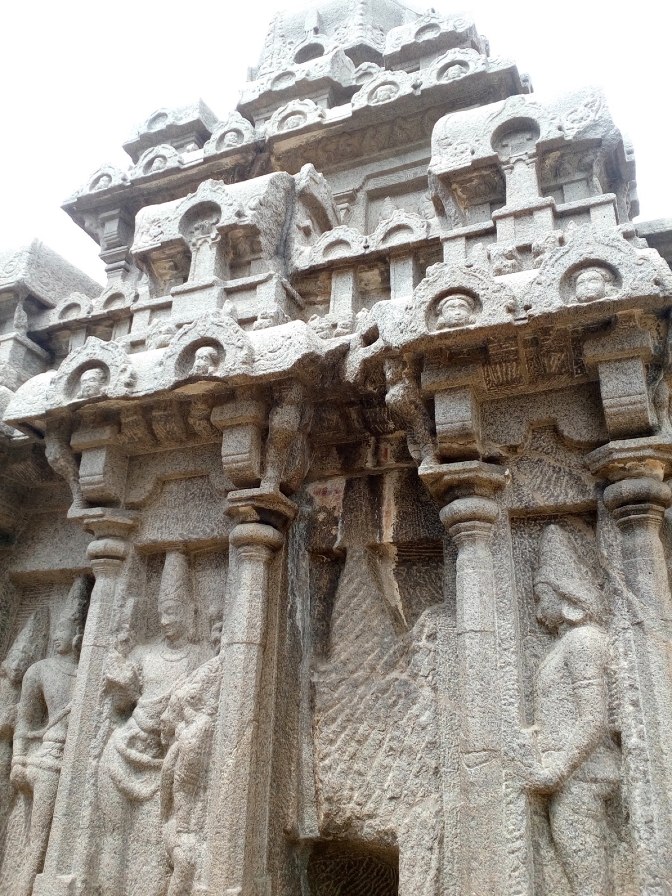 Figures carved across a vast open-air stone relief