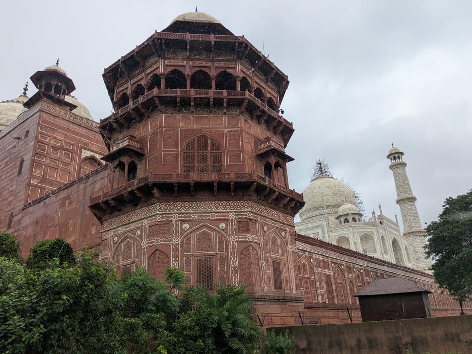 A red sandstone pavilion at Agra Fort with the Taj Mahal in the distance
