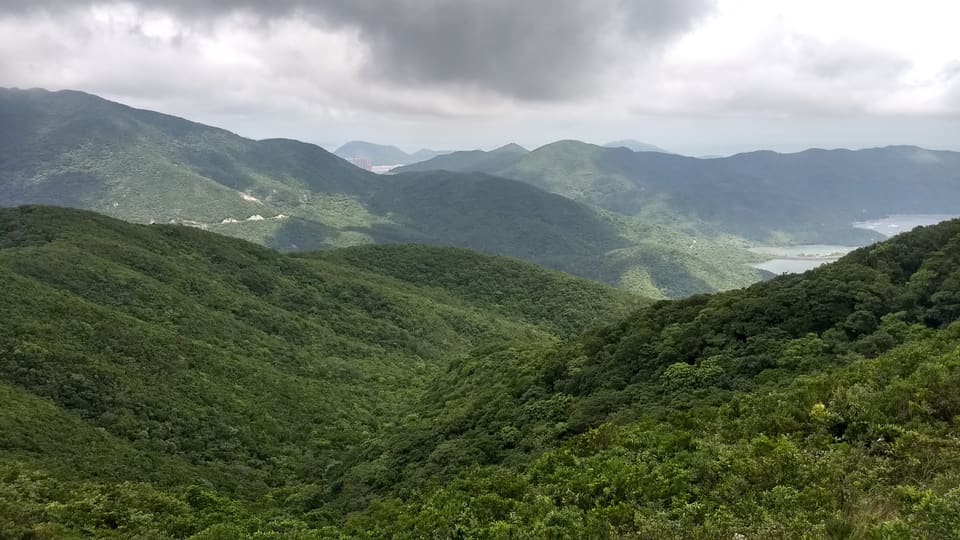 Calm reservoir water and green hills at Tai Tam
