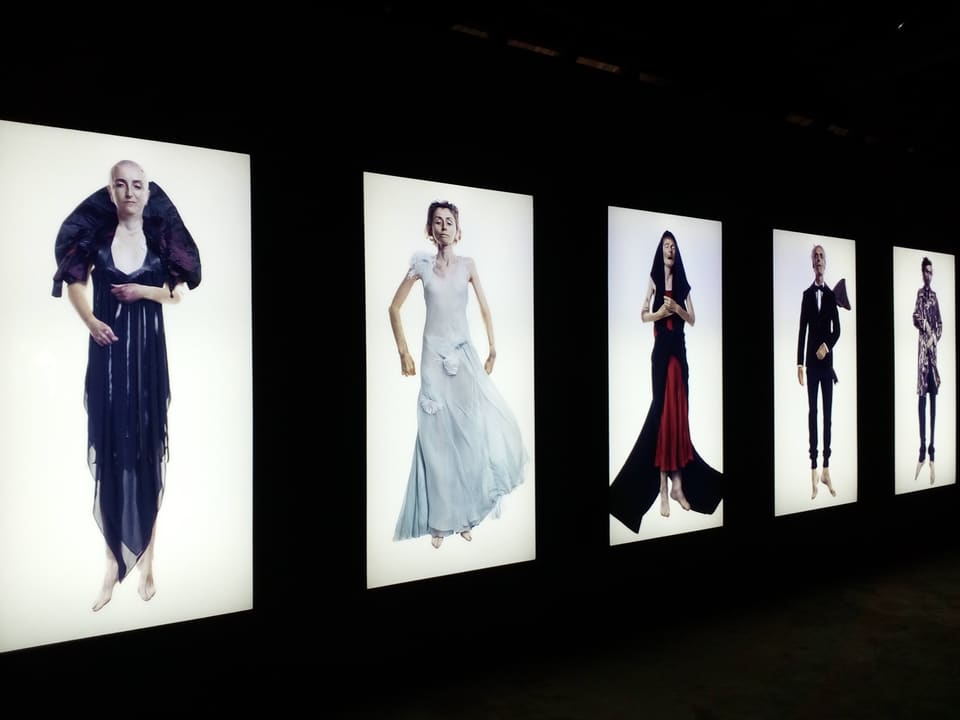Illuminated portrait installations in a dark Kochi Biennale gallery