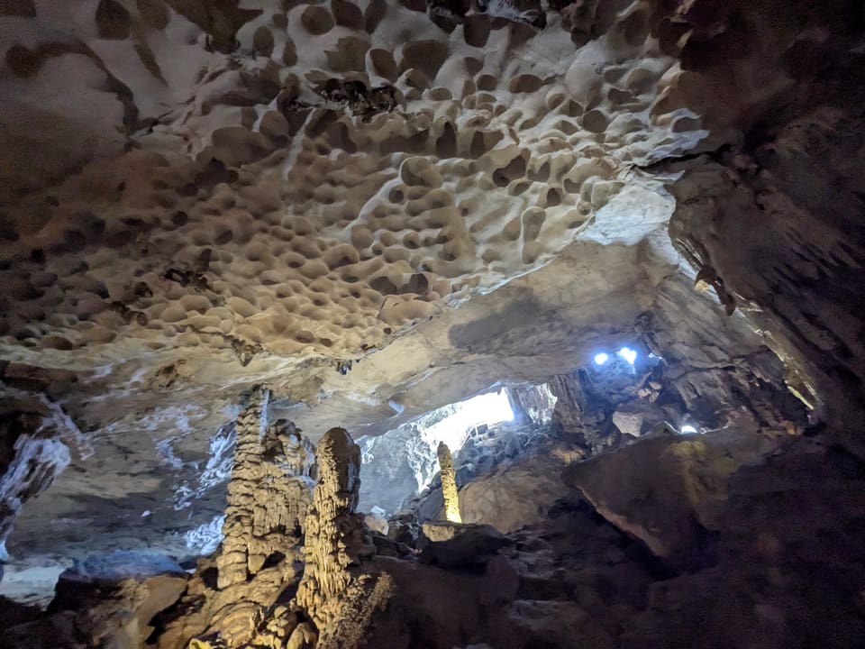 Illuminated limestone formations inside Sung Sot Cave