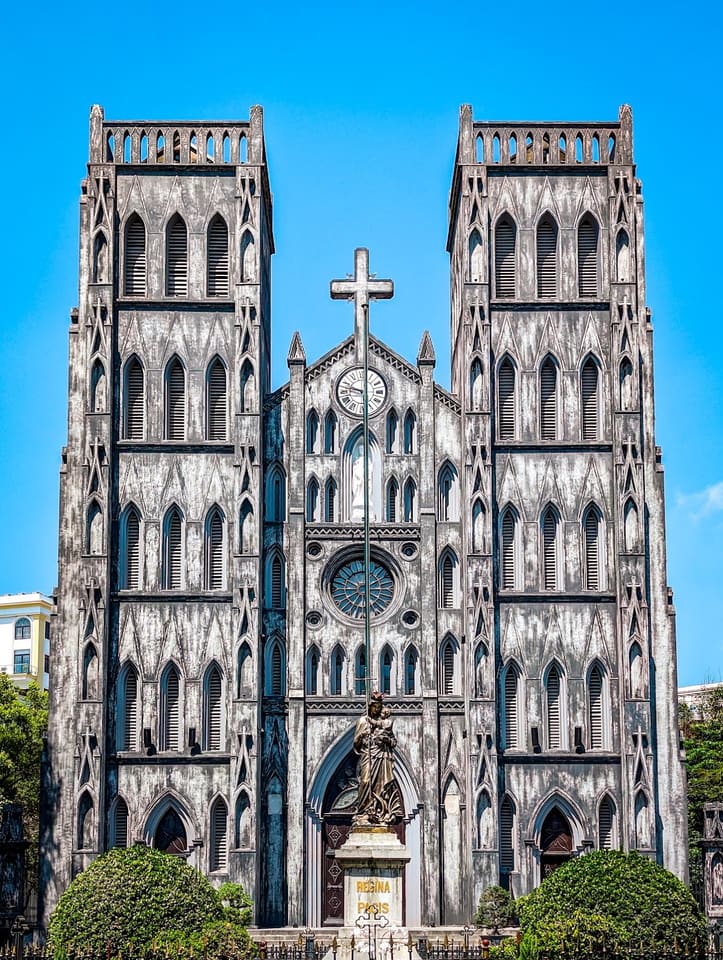 Twin towers and weathered stone façade of St Joseph's Cathedral in Hanoi