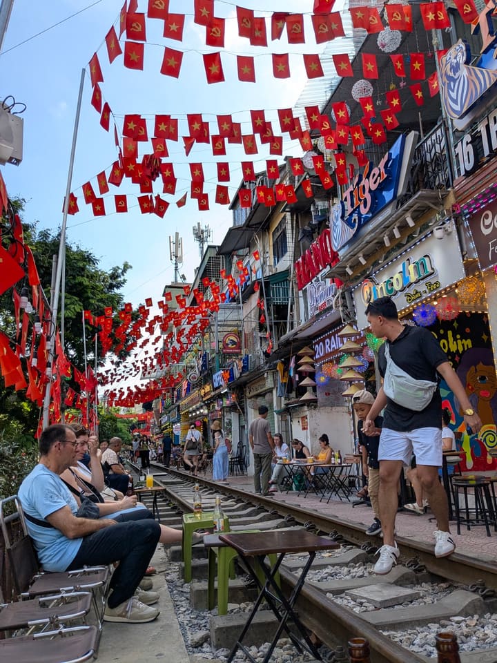 Colourful cafes and visitors beside the railway at Hanoi Train Street