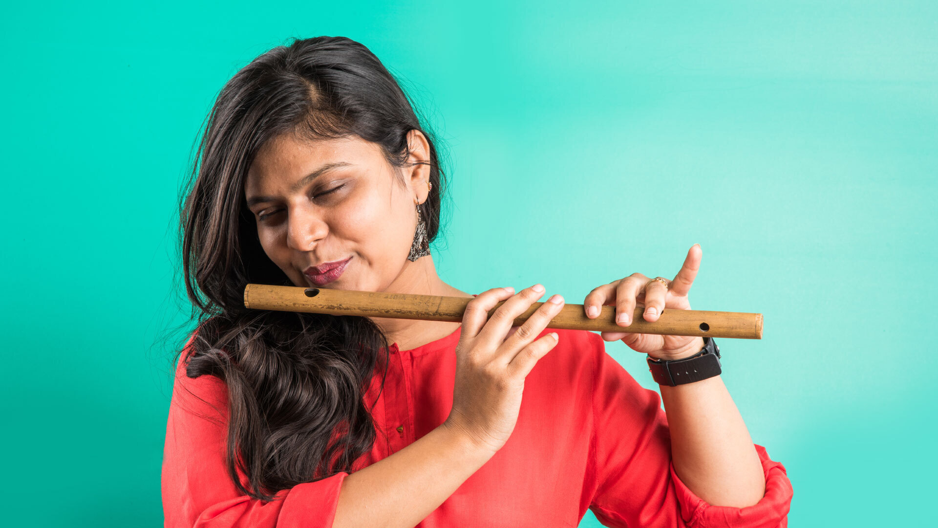 A person sitting cross‑legged by a lotus pond in India, eyes closed, holding hands in meditation posture, soft flute‑player at distance, dawn light filtering through trees