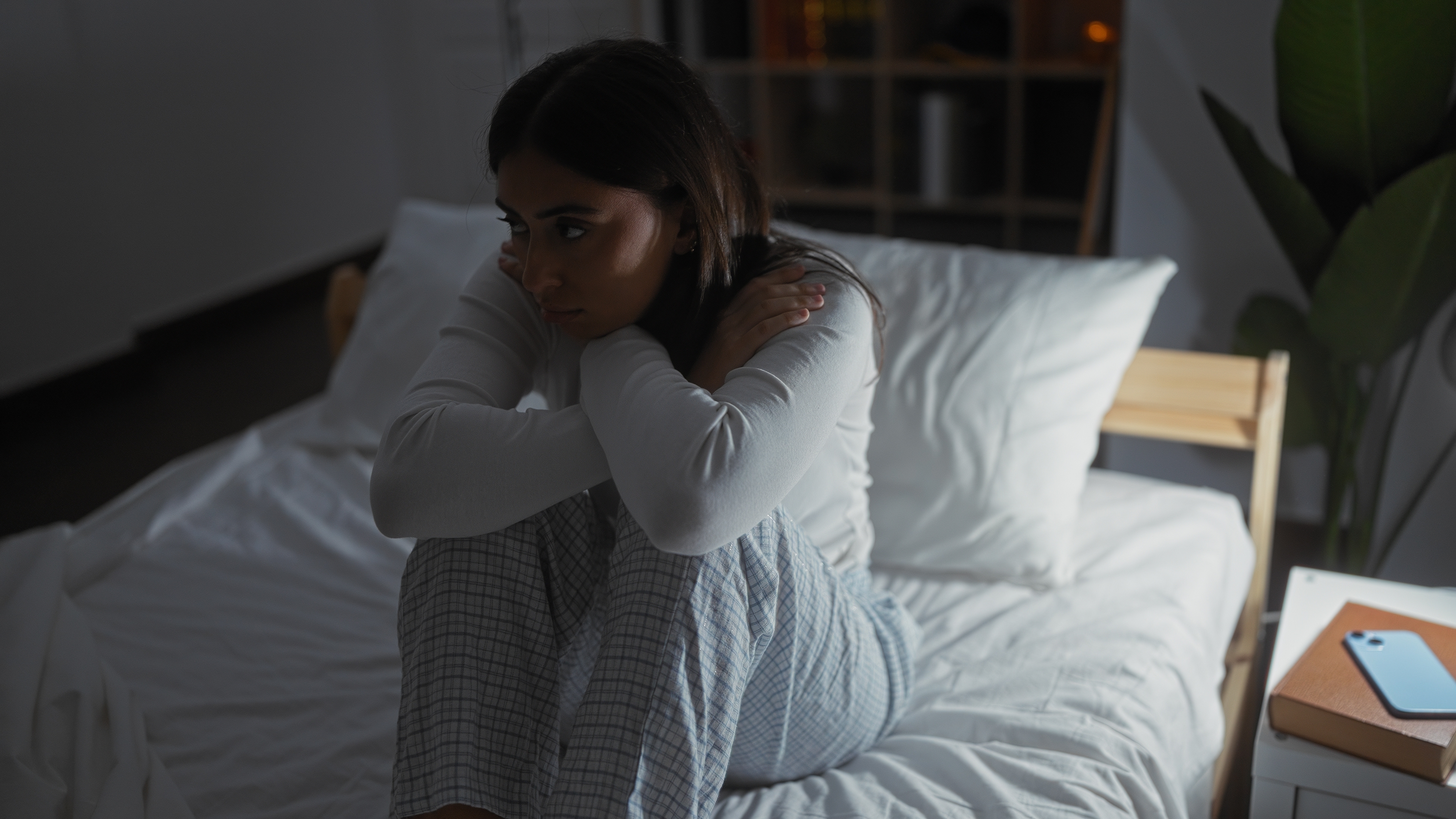 A calm Indian woman meditating at night with a journal, showing how to stop overthinking and negative thoughts.