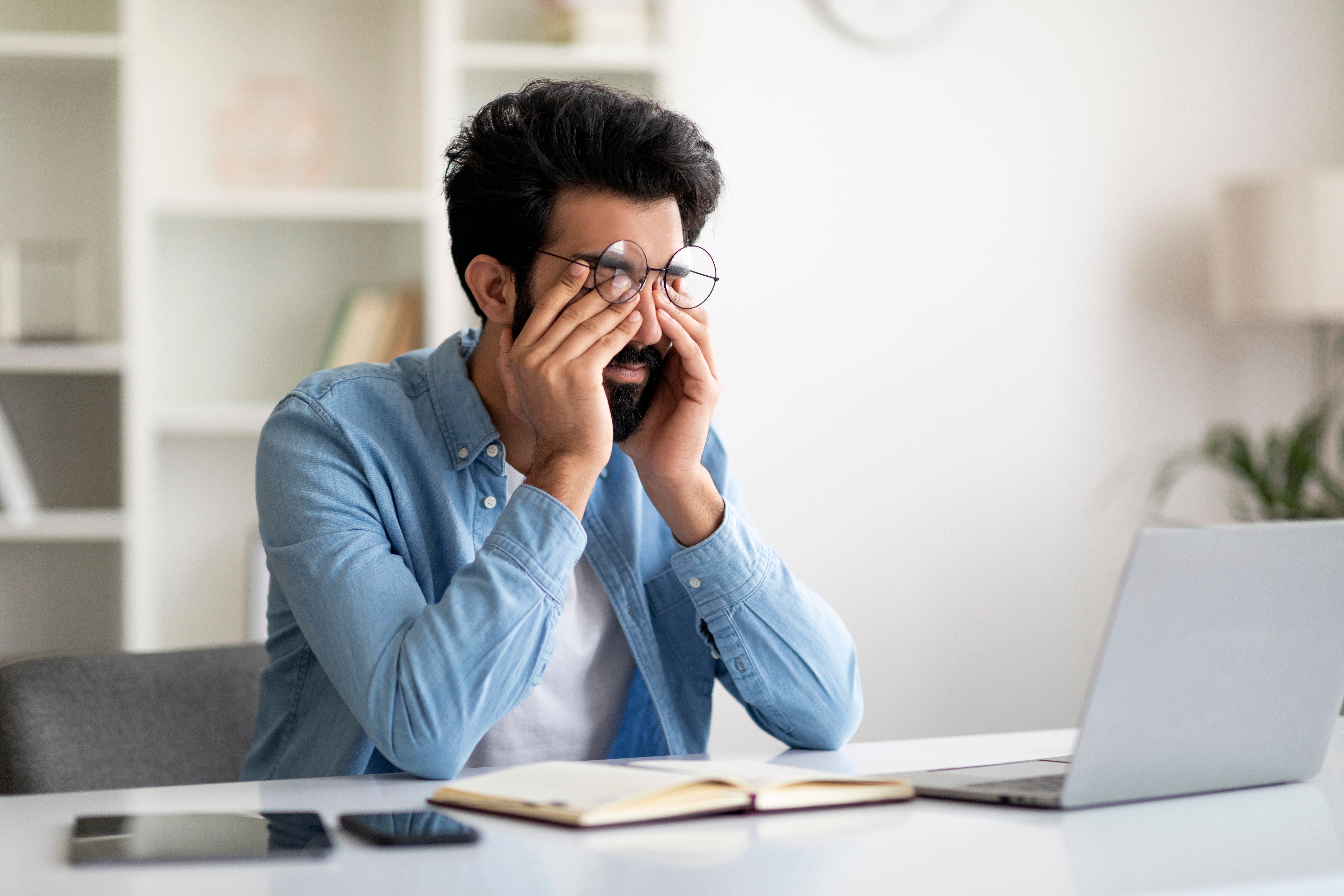 Concerned Indian man thinking about how elevated cortisol levels from chronic stress can lead to depression, anxiety, and emotional imbalance.