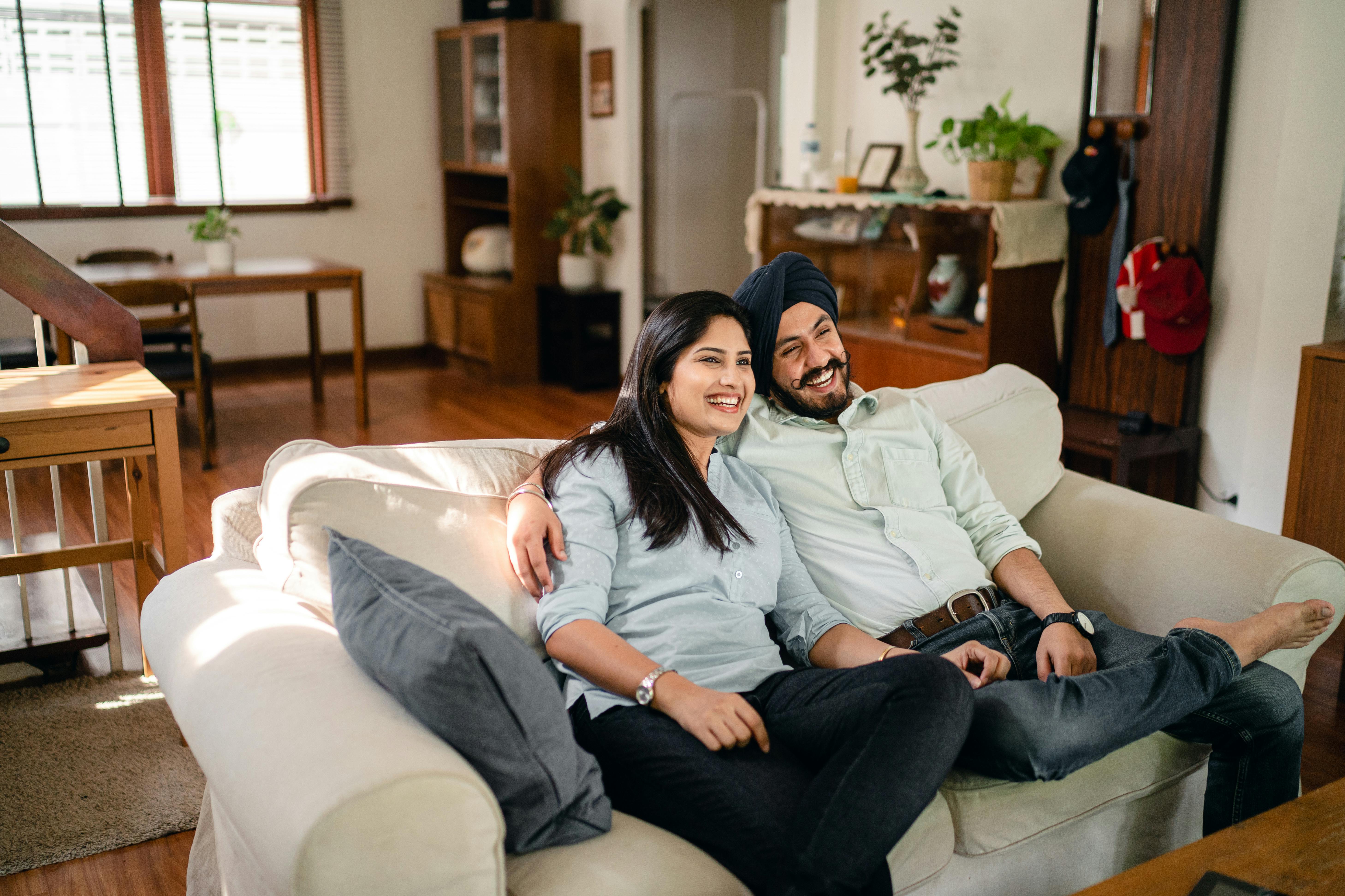 Indian couple sitting together in a warm, comfortable counseling office speaking with a professional marriage counsellor, representing hope and relationship healing