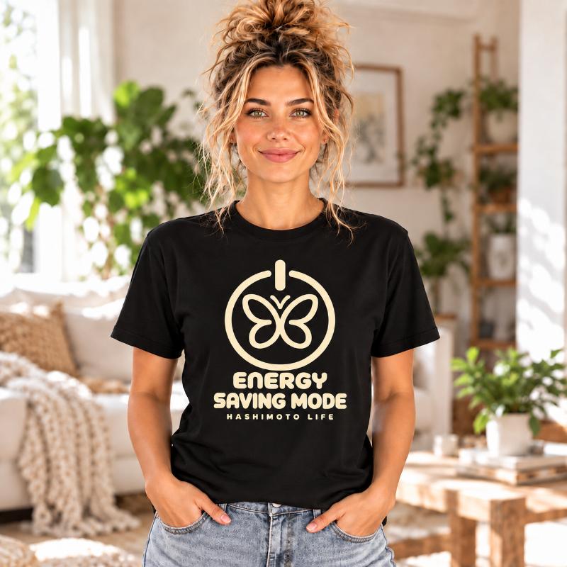 Frau im schwarzen Hashimoto Energy Saving Mode T-Shirt mit cremefarbenem Schmetterling.
