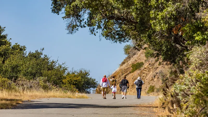 Una familia caminando por un sendero llano en un parque nacional
