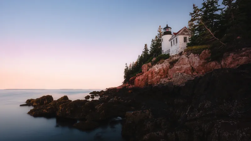 El faro Bass Harbor Head Light sobre acantilados de granito rosa al atardecer