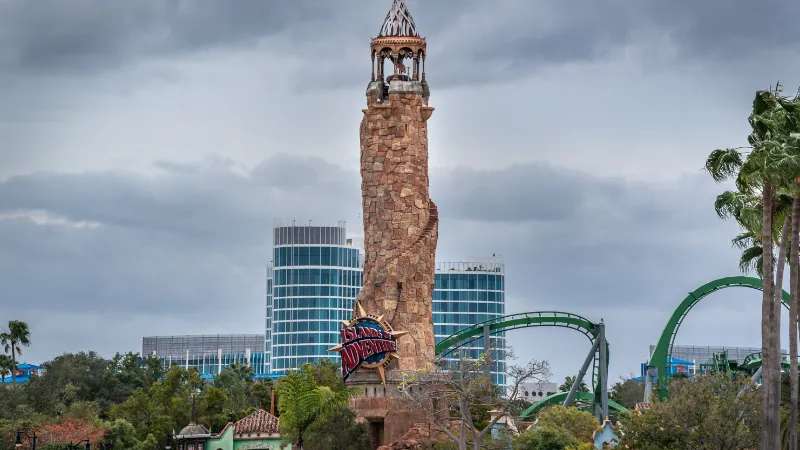 Faro de la entrada de Islands of Adventure con la montaña rusa de Hulk, en Universal Orlando