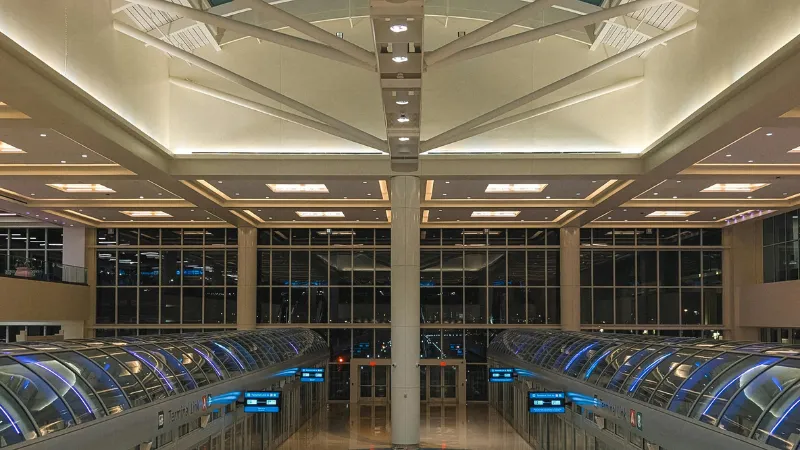 Interior de una terminal de aeropuerto con el andén del tren interno, de noche