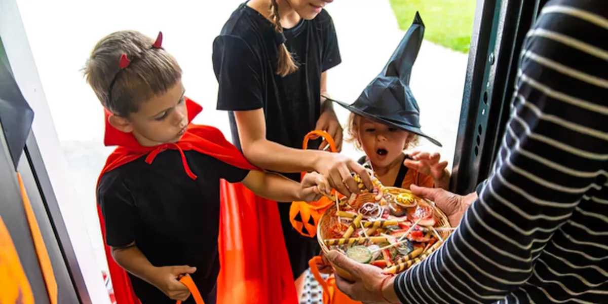 Chicos disfrazados haciendo trick-or-treat en Halloween