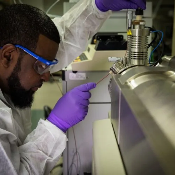 A technician collecting a drinking-water sample for PFAS laboratory analysis
