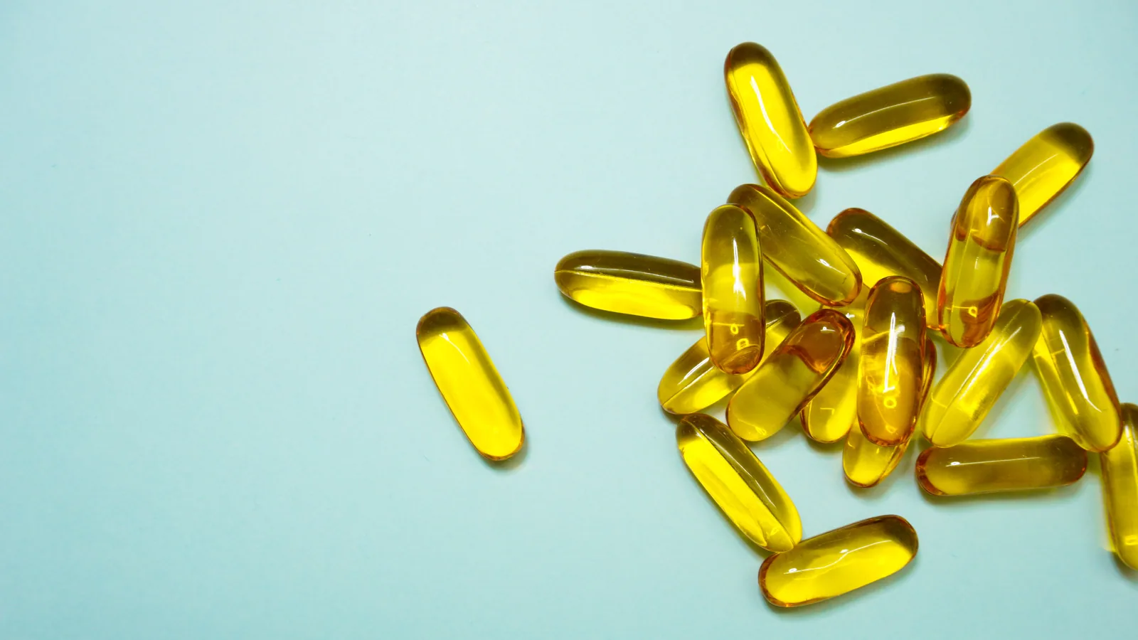 Açık mavi zemin üzerinde omega-3 yumuşak kapsülleri