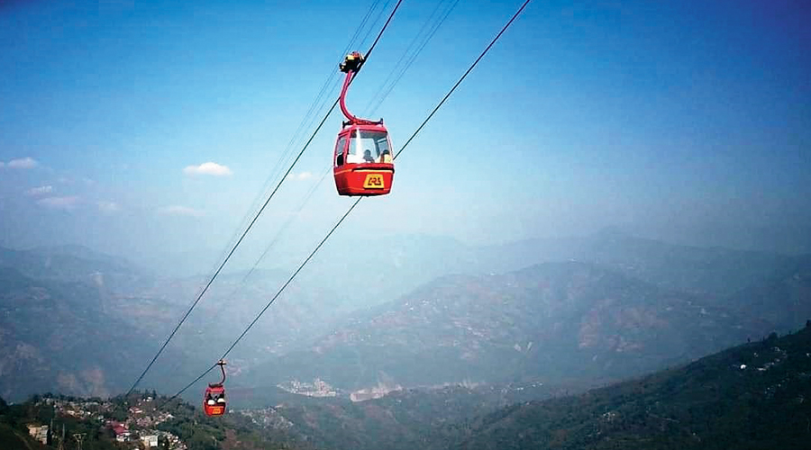 A scenic view of the Darjeeling Ropeway cabins moving over tea gardens