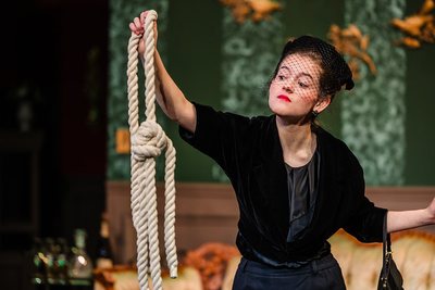 Tiger Drama performer in a black costume holding a rope prop in Clue