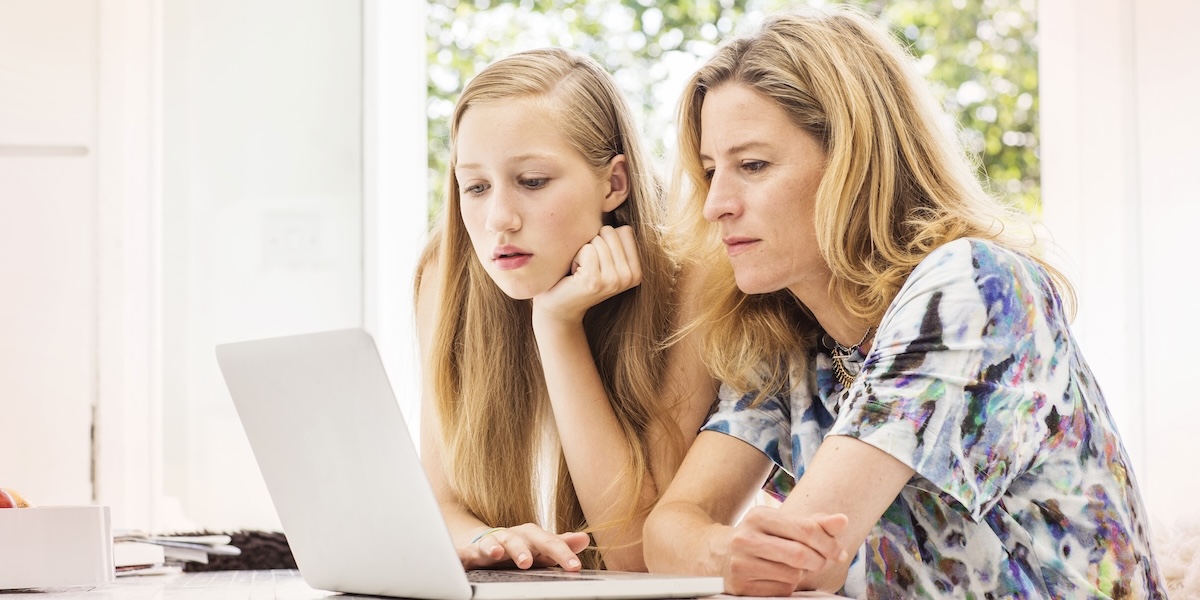 Mom and daugher viewing laptop