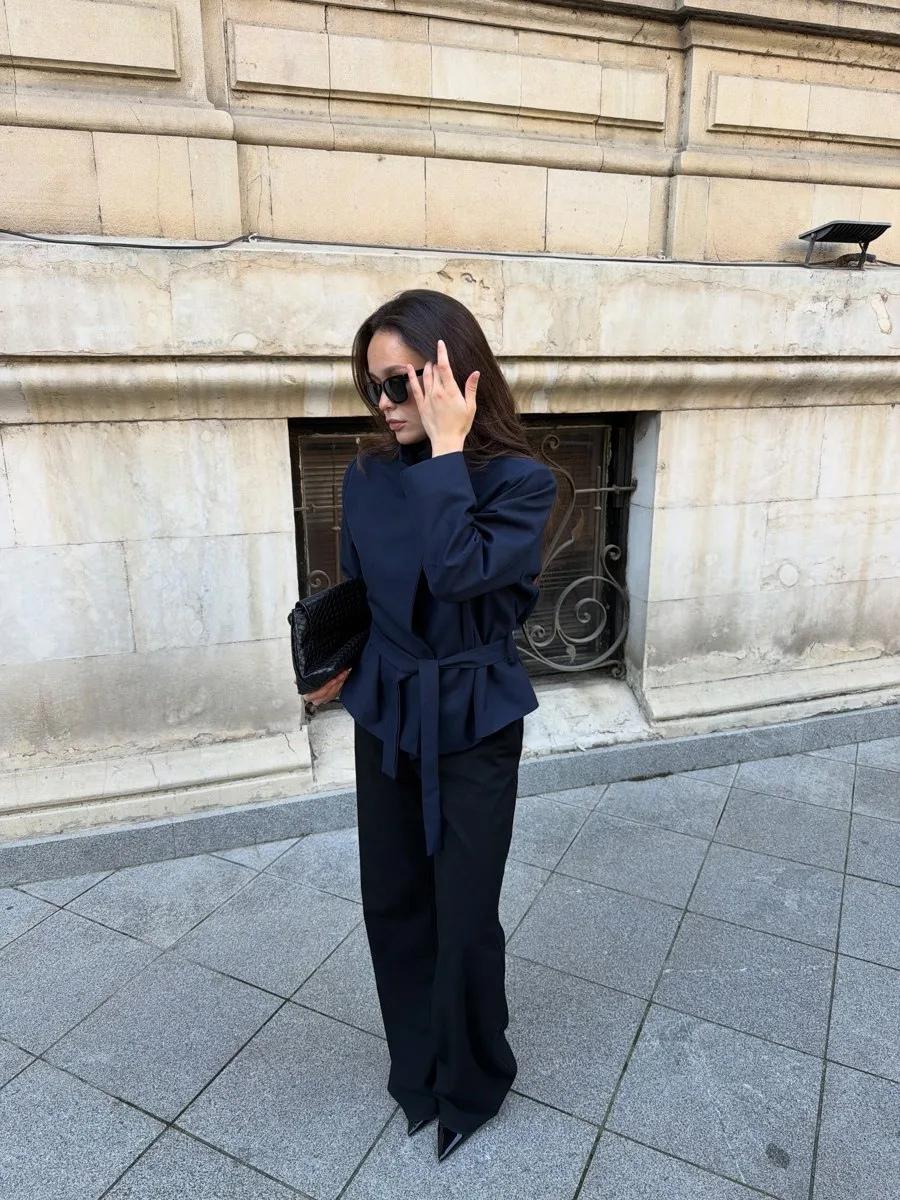 Midnight Blue trench-blazer tied at the waist and styled with black wide-leg trousers and a black clutch.