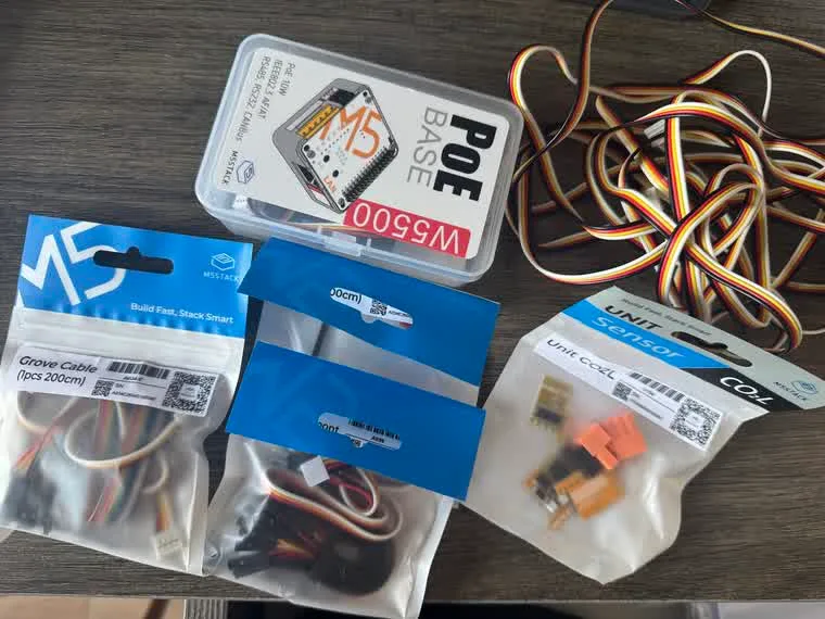 The order as it arrived: the boxed PoE base W5500, sealed packets of Grove cables and Grove-to-Dupont jumpers, and the Unit CO2L sensor with its orange connectors