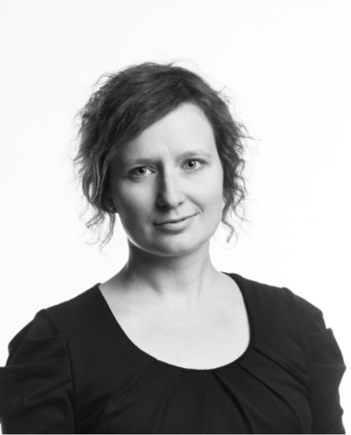 Katarzyna, a Dutch woman looking directly at the camera with a light grin. The photo is in black and white and highlights her eyes and smile.