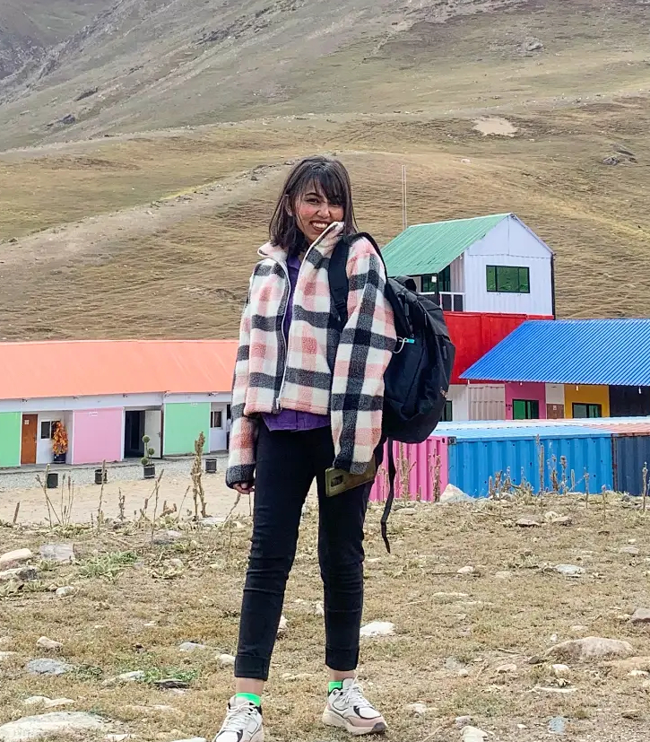 Portrait of Sarwat, a Pakistani woman, smiling in front of the Google logo.