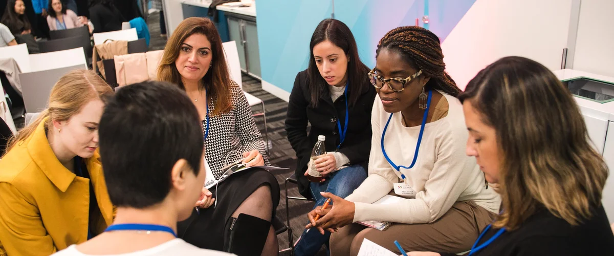 A diverse group of women engaged in a conversation.