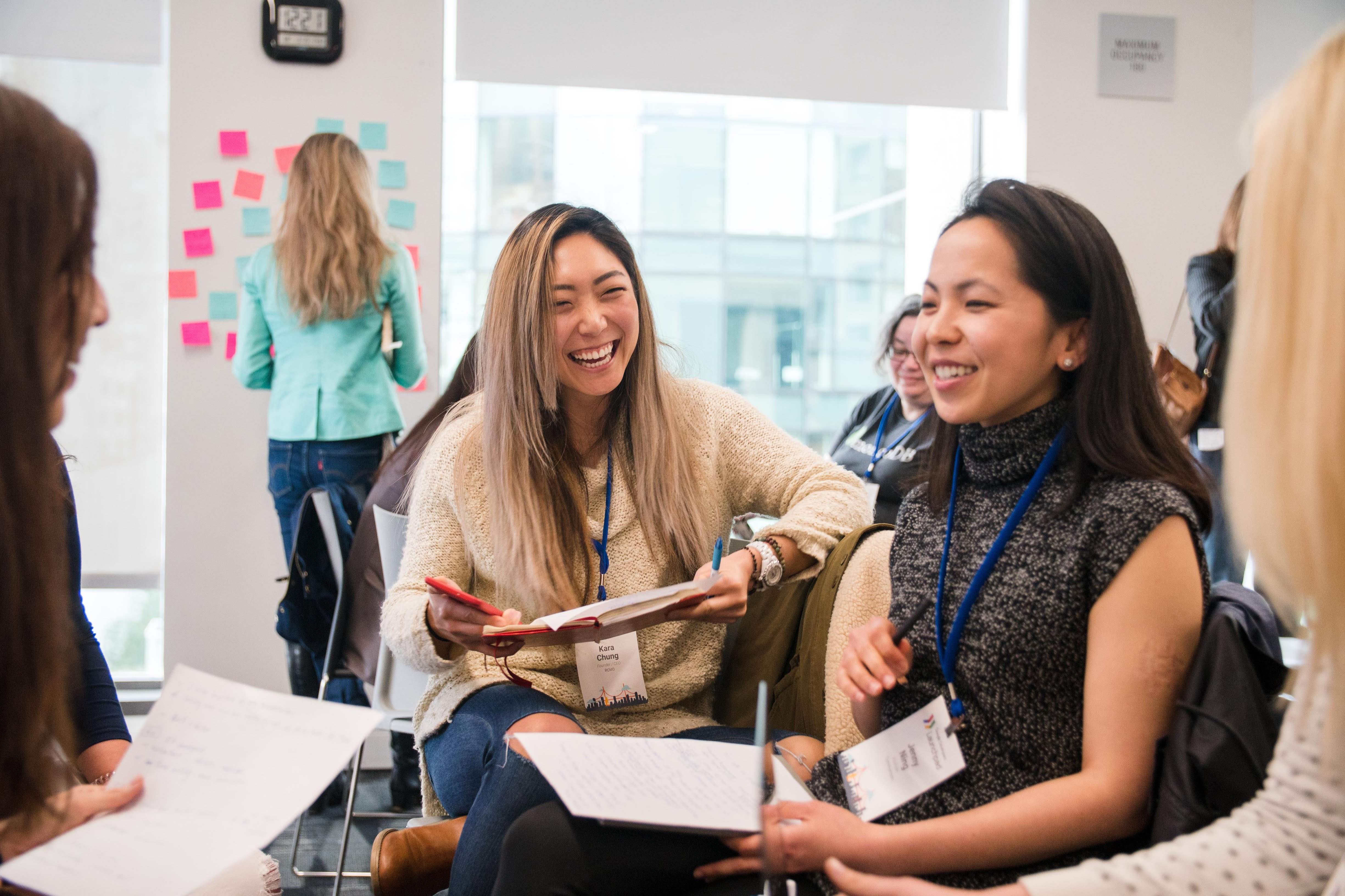 A collaborative brainstorming session. A group of women engage in a lively discussion, their laughter reflecting a positive and energetic atmosphere.