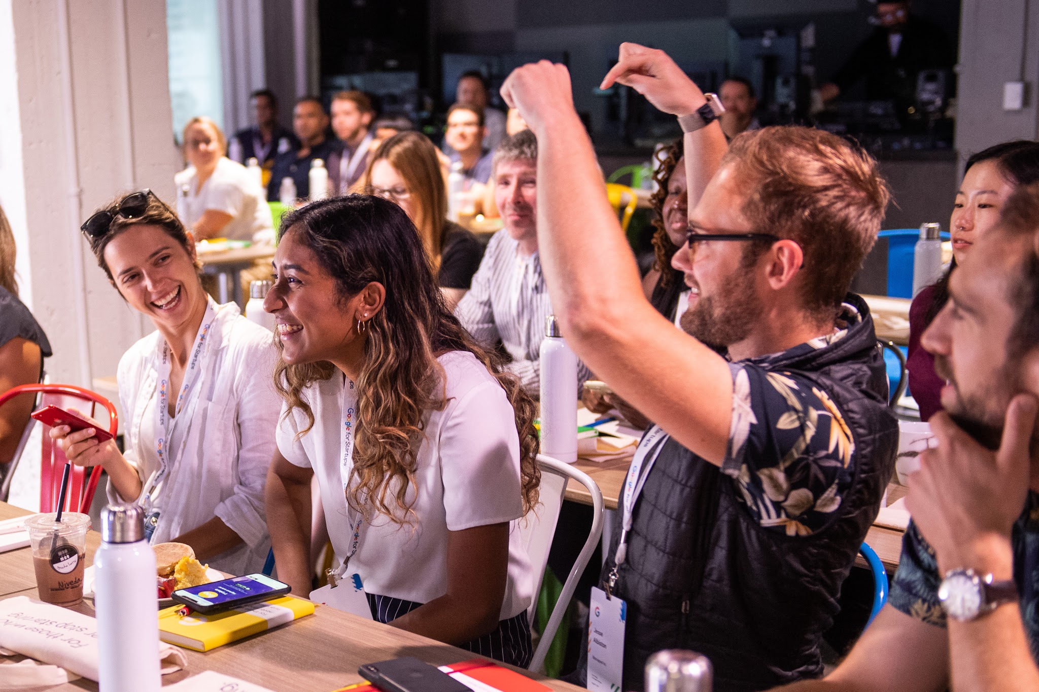 A diverse group enjoys a fun moment together. People laughingly engage with each other, with one person playfully gesturing.