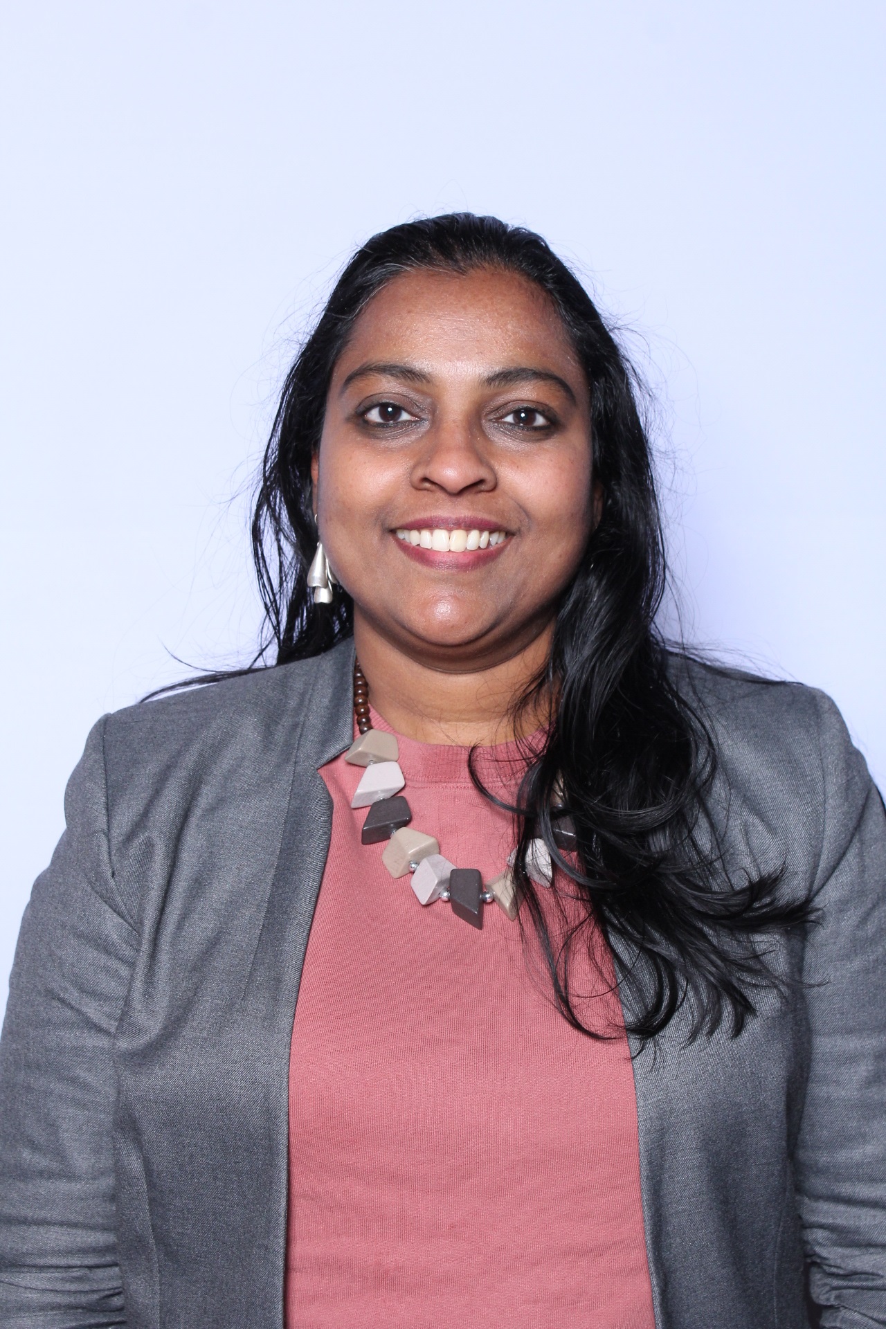 A photo of Rafna, a woman of color smiling at the camera.