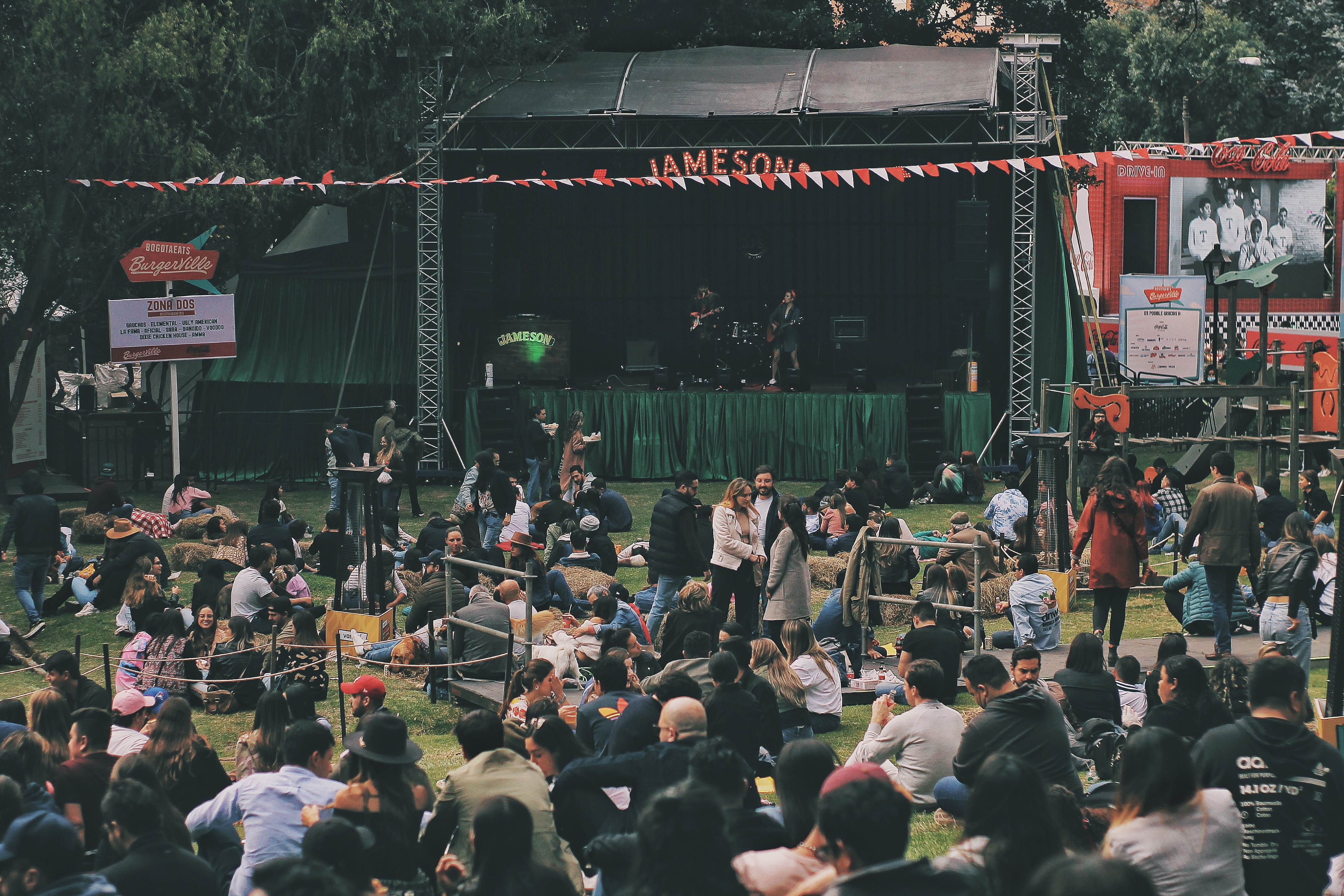 Festival Burgerville con escenario y asistentes
