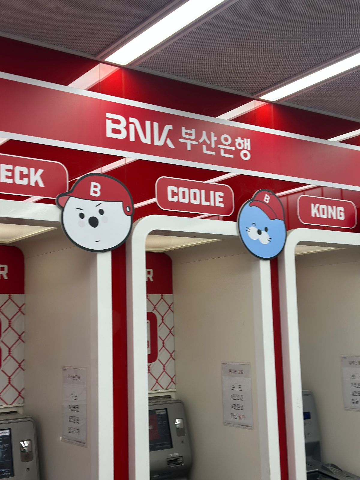 BEC K, COOLIE, KONG 이름판과 캐릭터 얼굴판이 달린 ATM 부스 상단