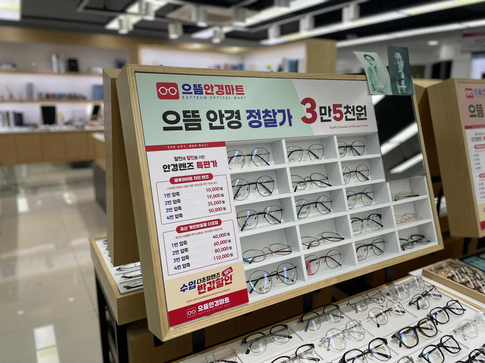 매장 안 안경 진열대 위에 놓인 정찰가 안내판과 렌즈 가격표