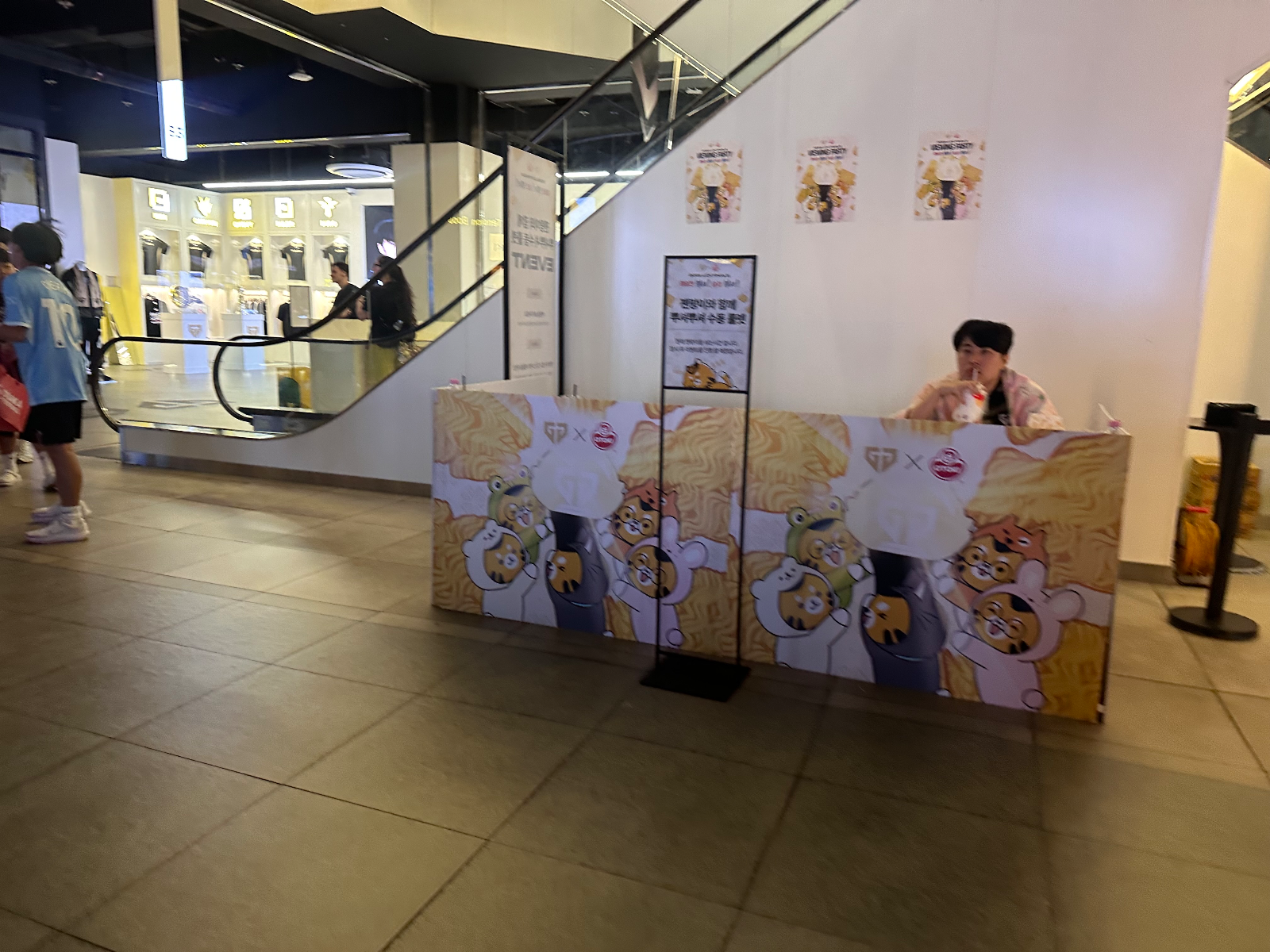 관람객이 지나다니는 이벤트 부스와 안내 배너