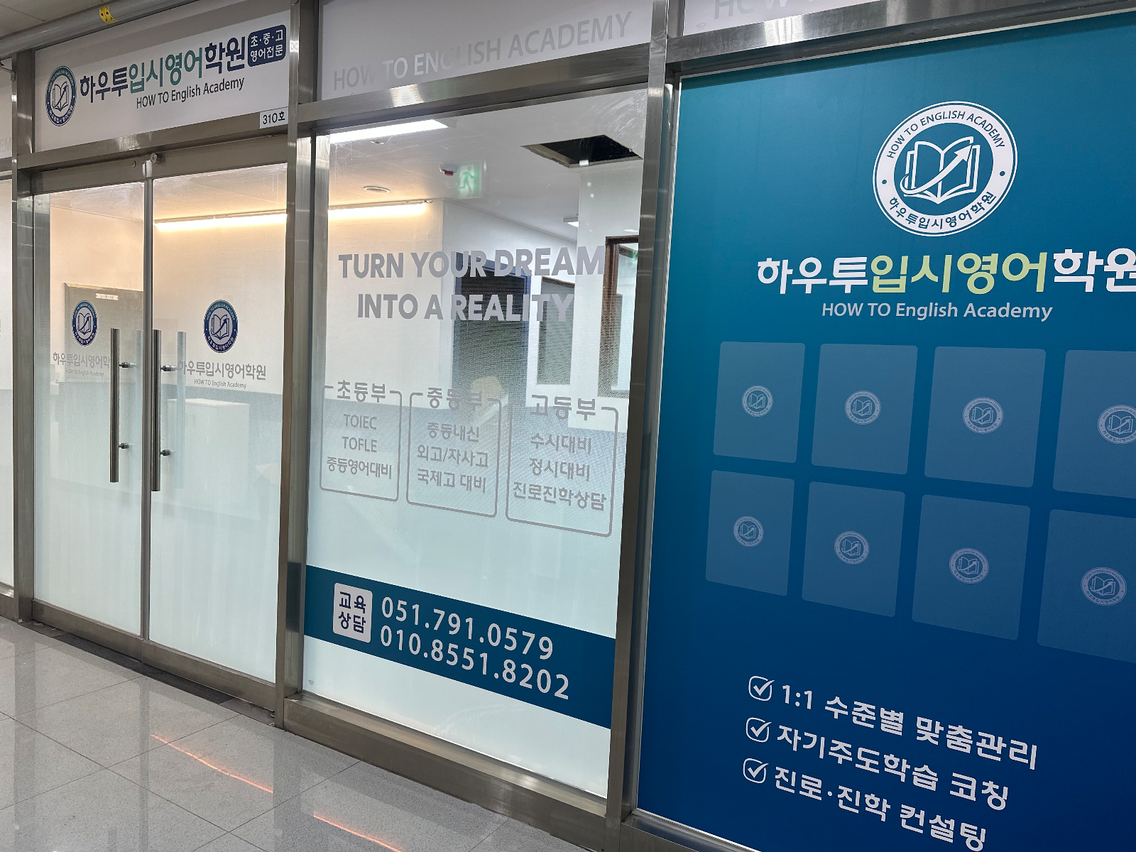 출입문과 파란 시트지 면이 나란히 보이는 학원 입구