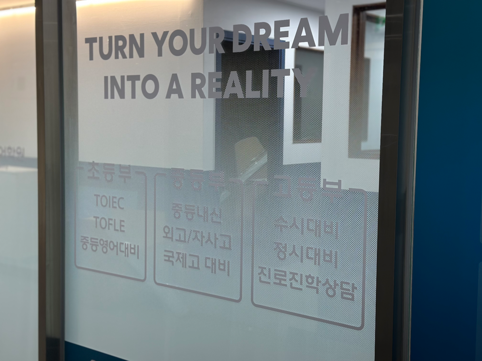 유리에 붙은 회색 레터링과 초등부 중등부 고등부 안내 박스 근접 사진