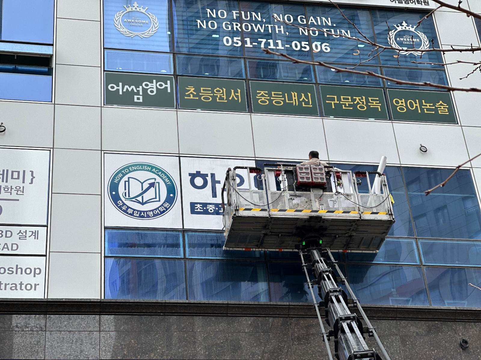 카고 스카이 바스켓에 올라 외벽 유리면에 시트지를 붙이는 작업자