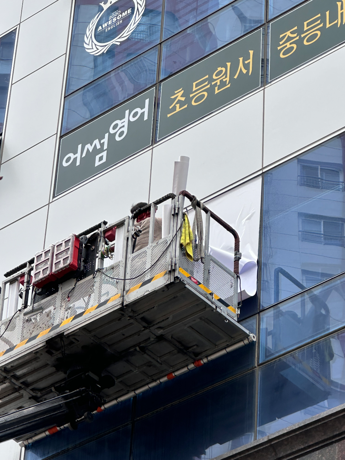 롤 상태의 시트지를 들고 유리면에 대는 작업자